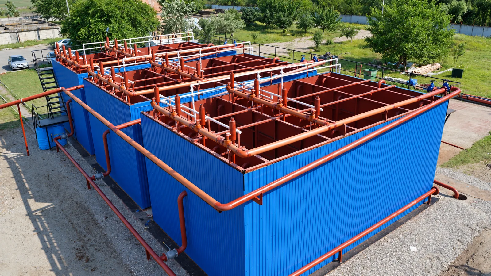 Real treatment facility with open process tanks, connecting pipes and maintenance walkways